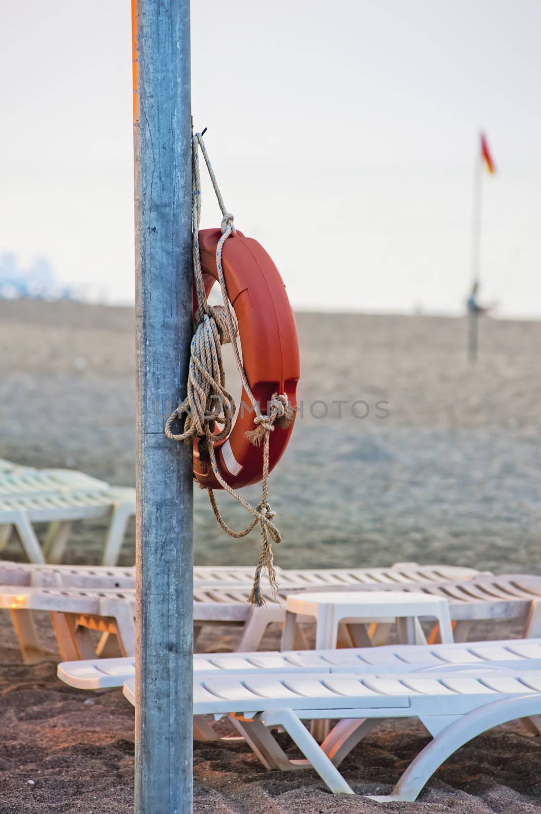 Lifebuoy hanging on a pole on the public beach.