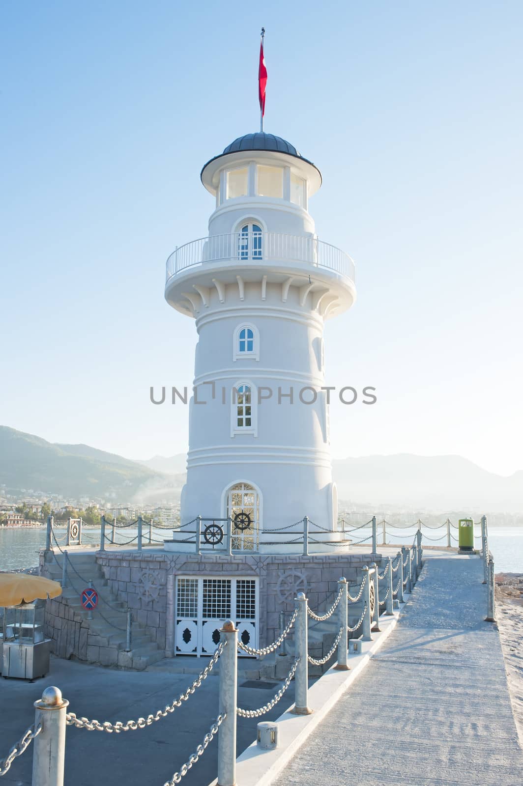 Landscape with a lighthouse in the harbor town of Alanya at dawn.