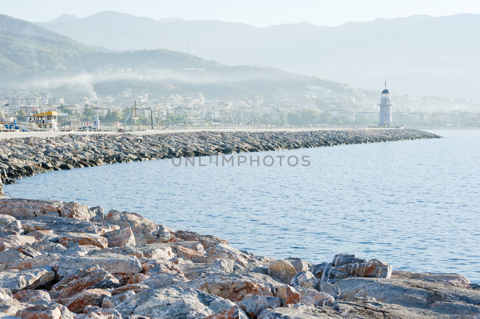 Landscape with a lighthouse in the harbor town of Alanya at dawn.