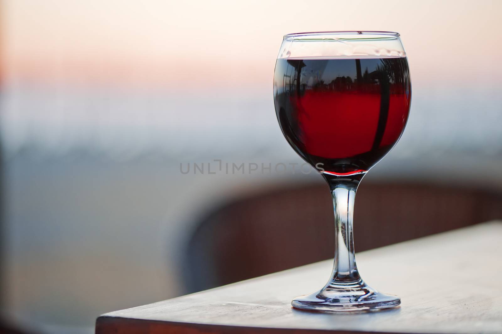 A glass of red wine at sunset.