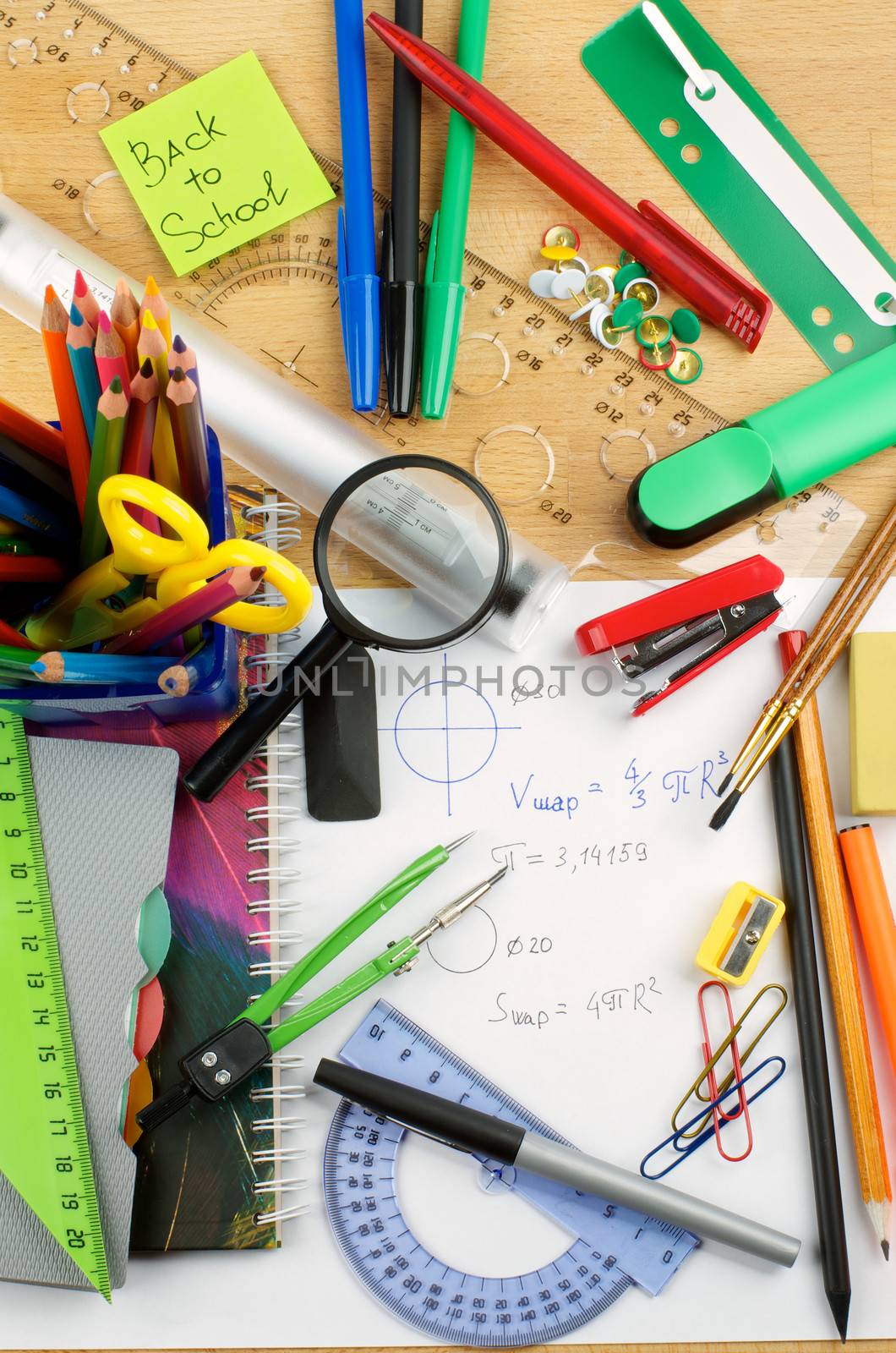 School Supplies with Note Pads, Pencils, Pens, Colored Pencils, Scissors, Pencil Sharpener, Buttons, Drawing Compass, Magnifier, Stapler, Slide-Rule and Ruler Lines on School Desk . Top View