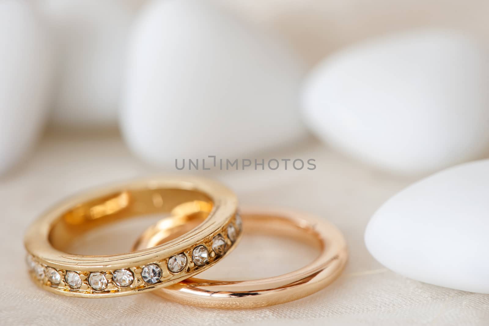 wedding favors and wedding ring on on colored background