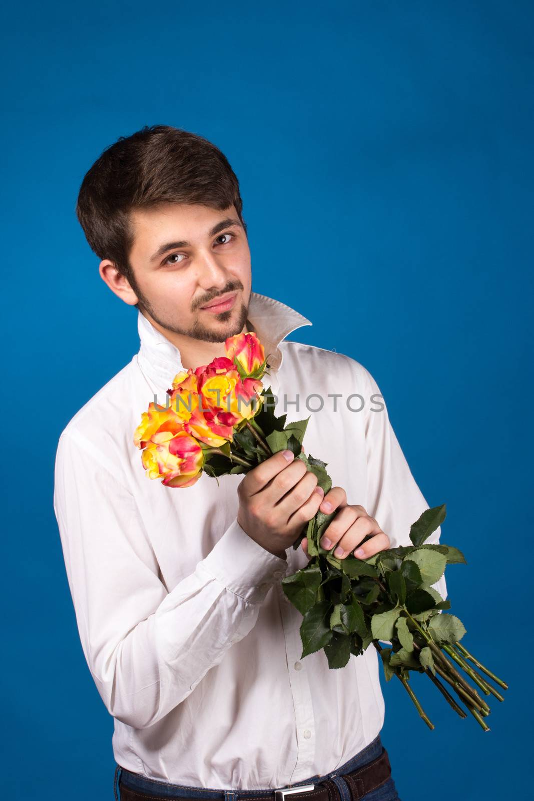 young man giving a red rose, on blue background