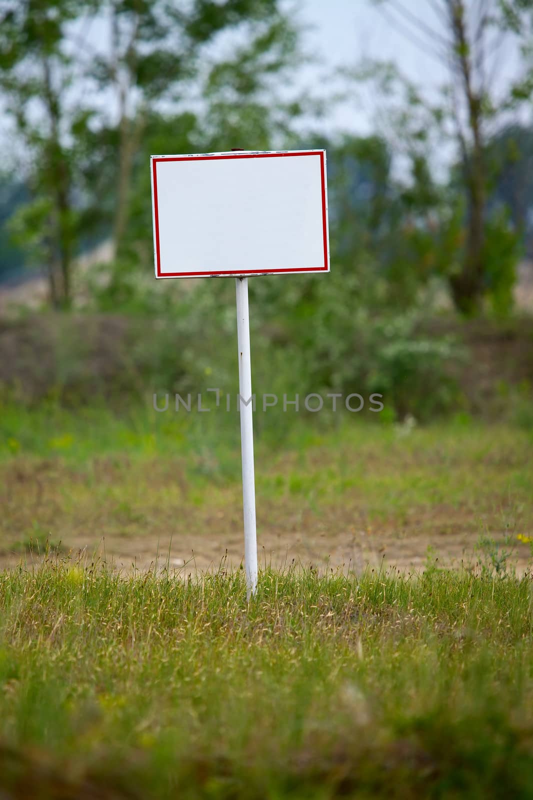 Empty signboard on a green field