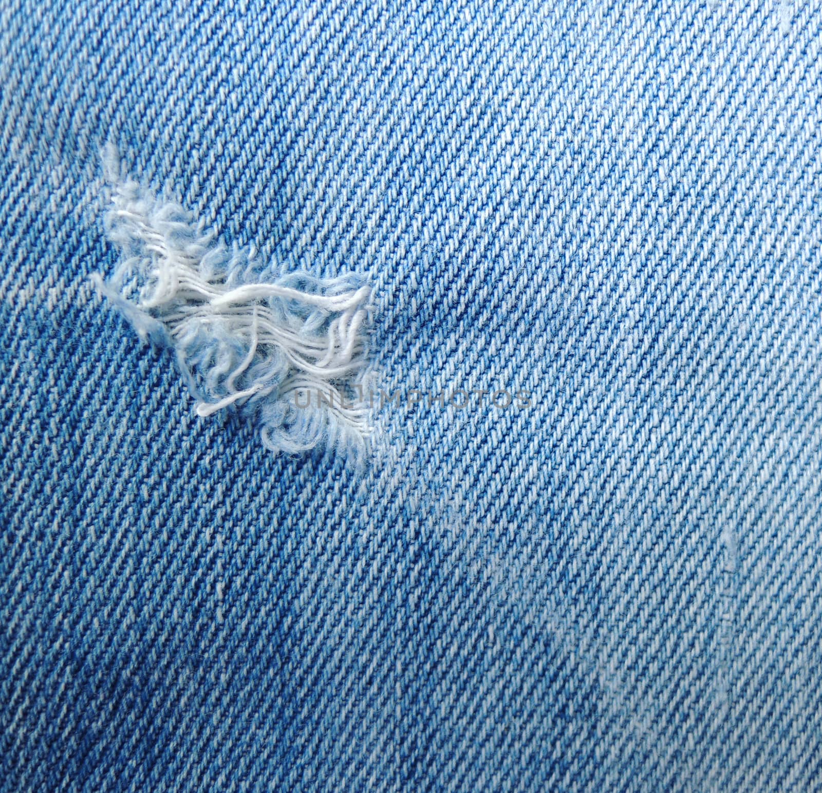 blue jean texture with a hole and threads showing

