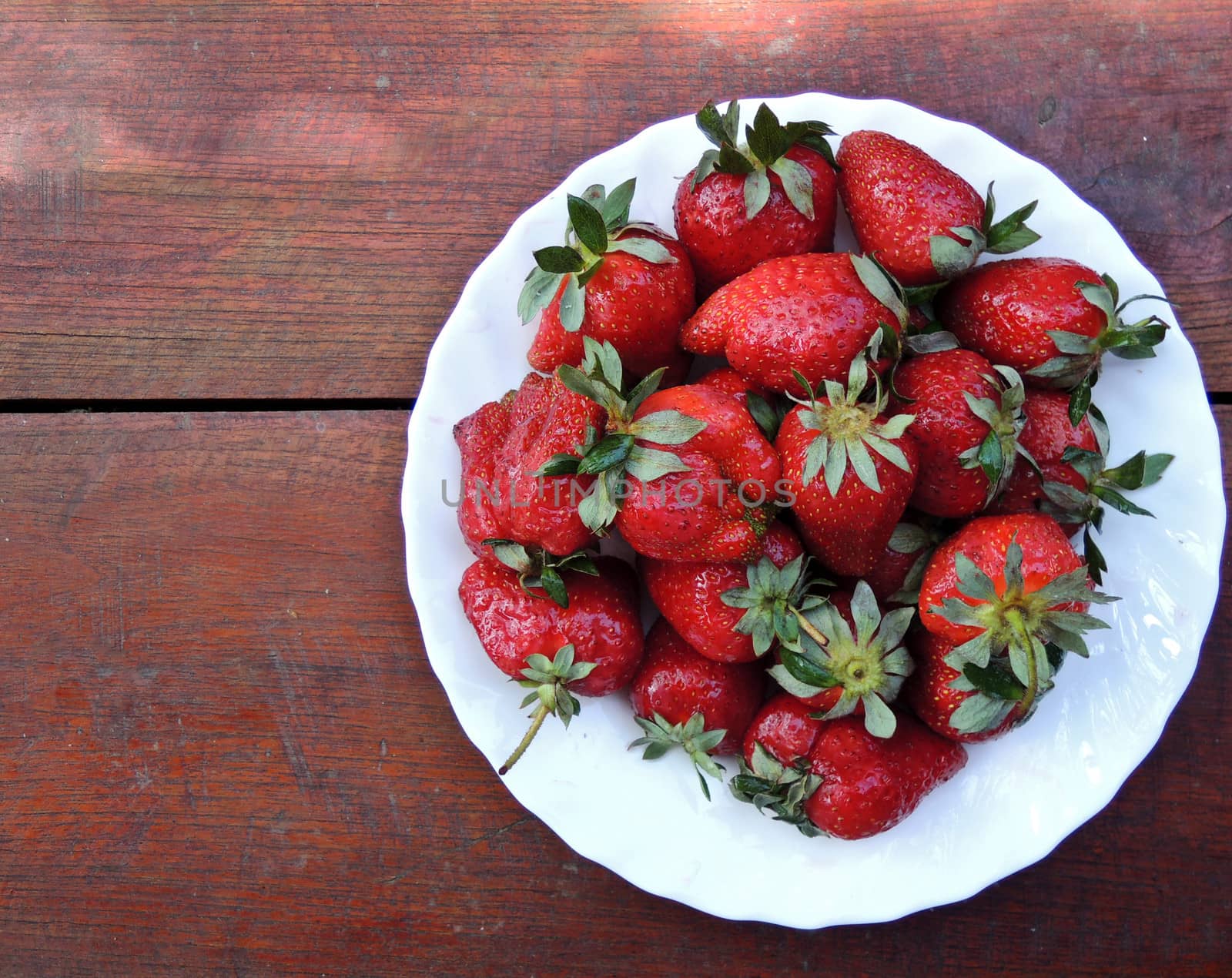 Strawberries on a plate on wooden table