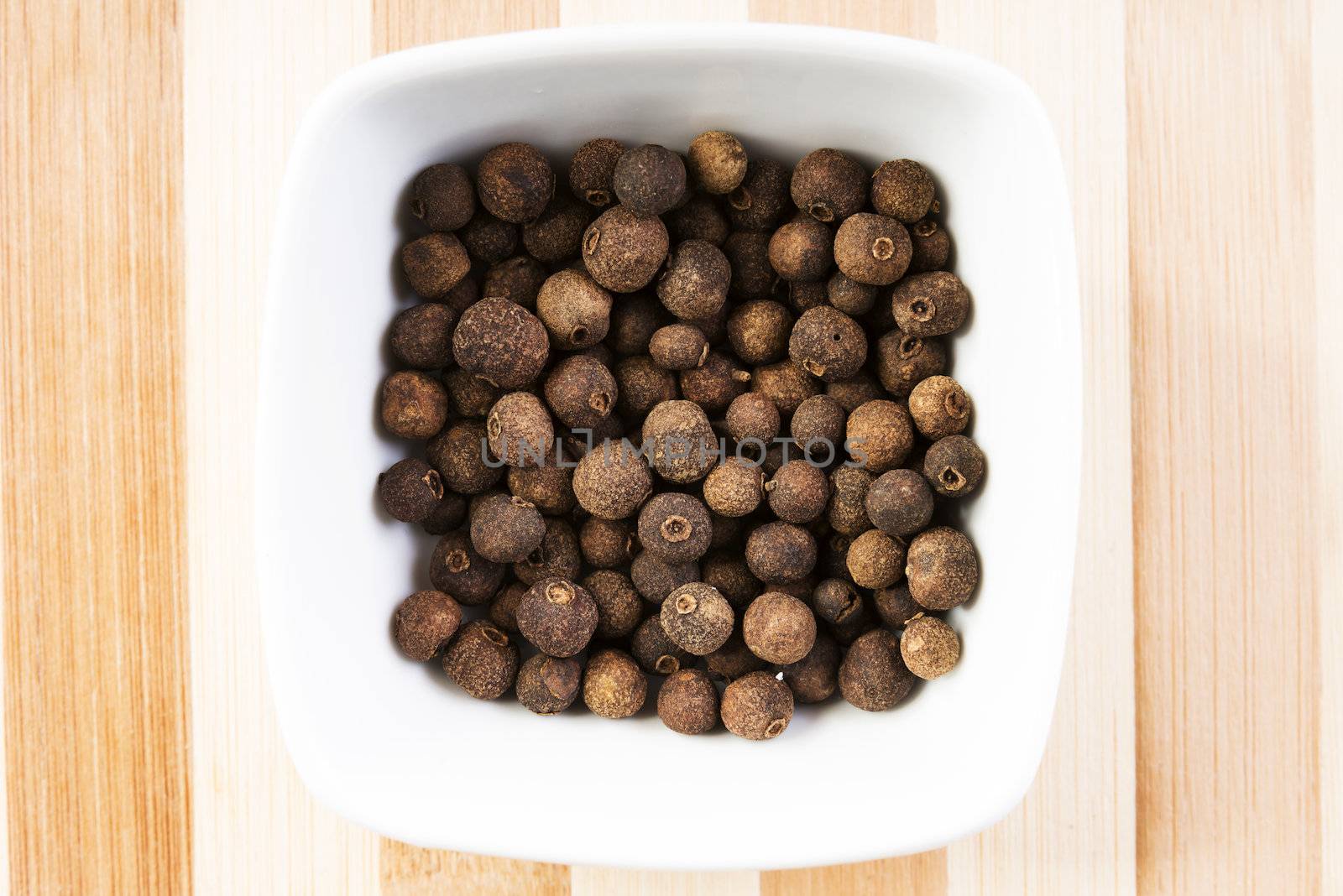 Allspice in bowl on table