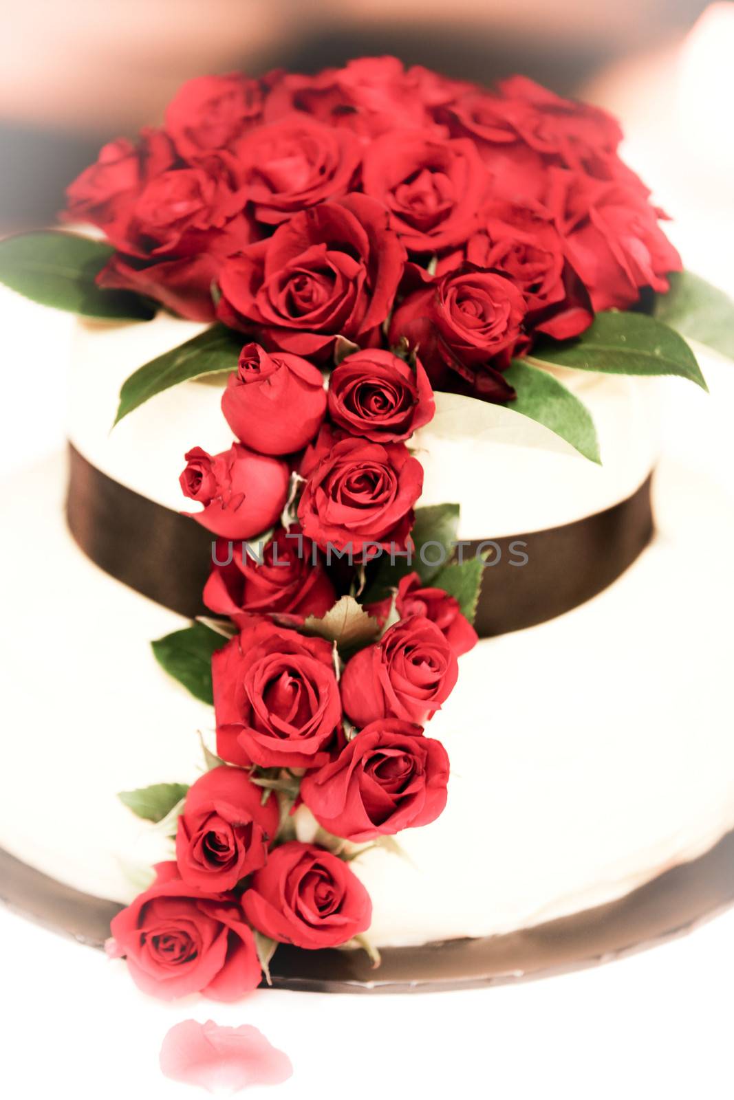 Beautifully decorated wedding cake with red roses