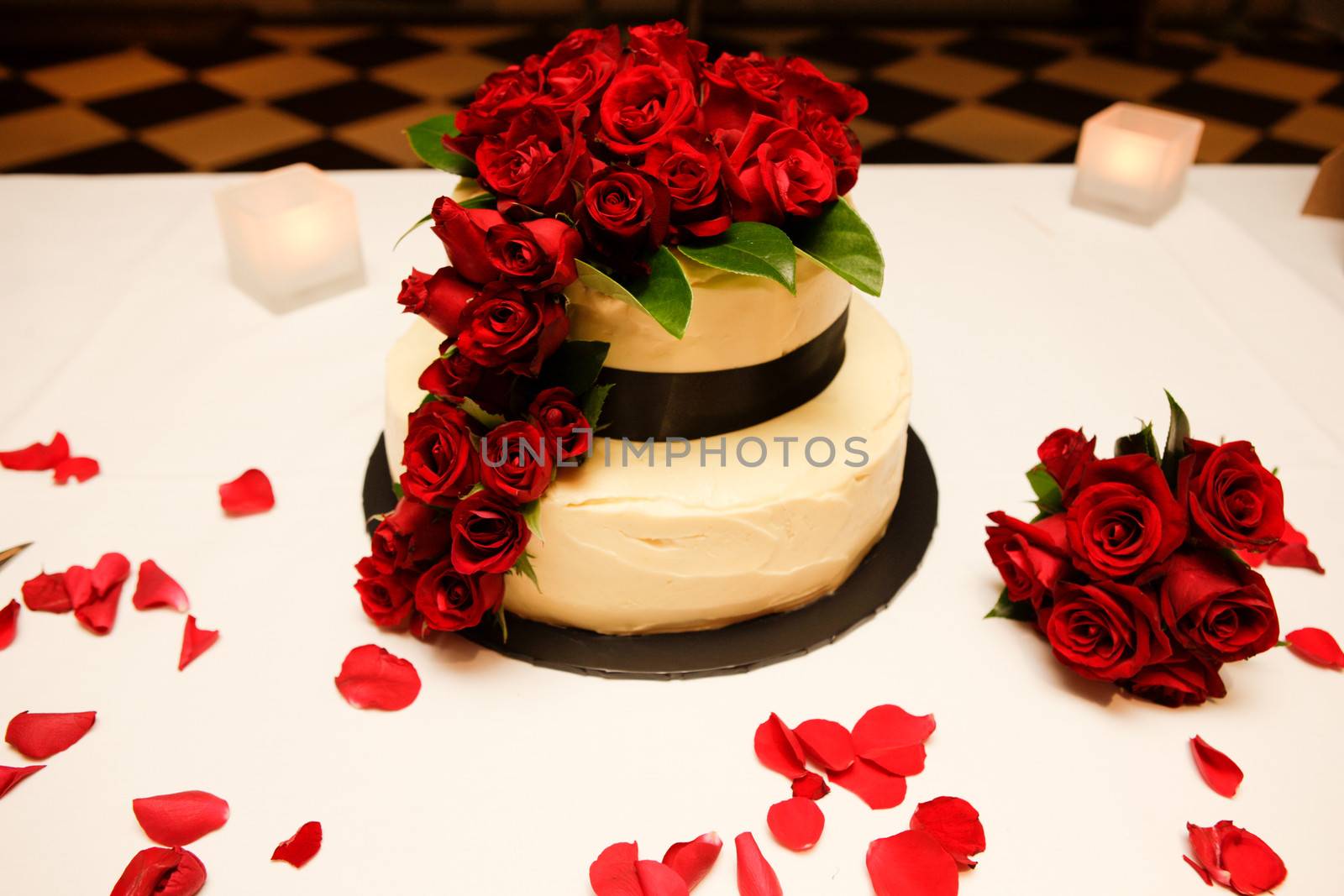 Table with a wedding cake decorated with red roses