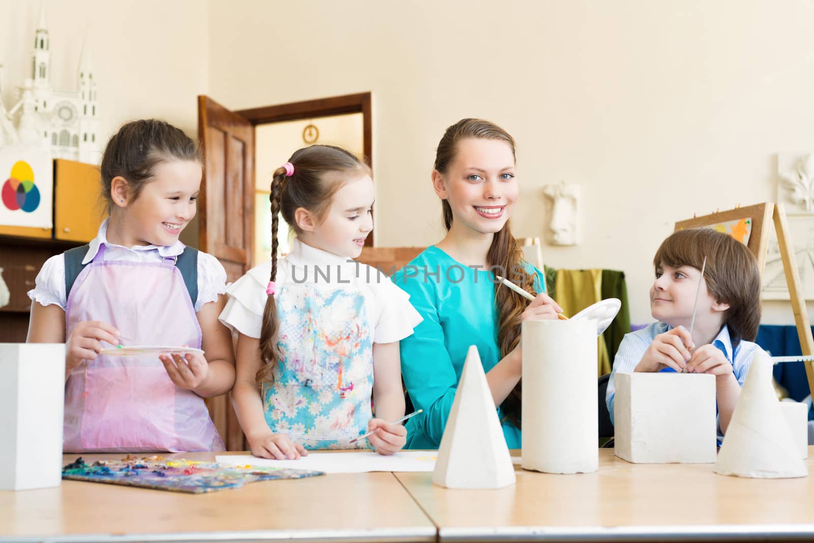 children draw with the teacher in the classroom drawing