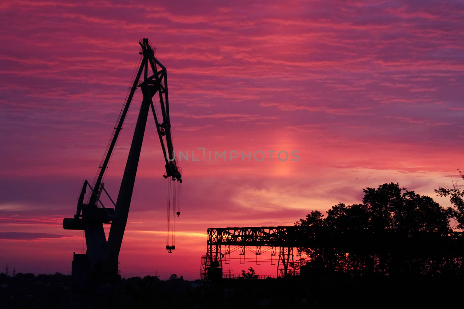 silhouette of crane on shipbuilding plant at sunrise