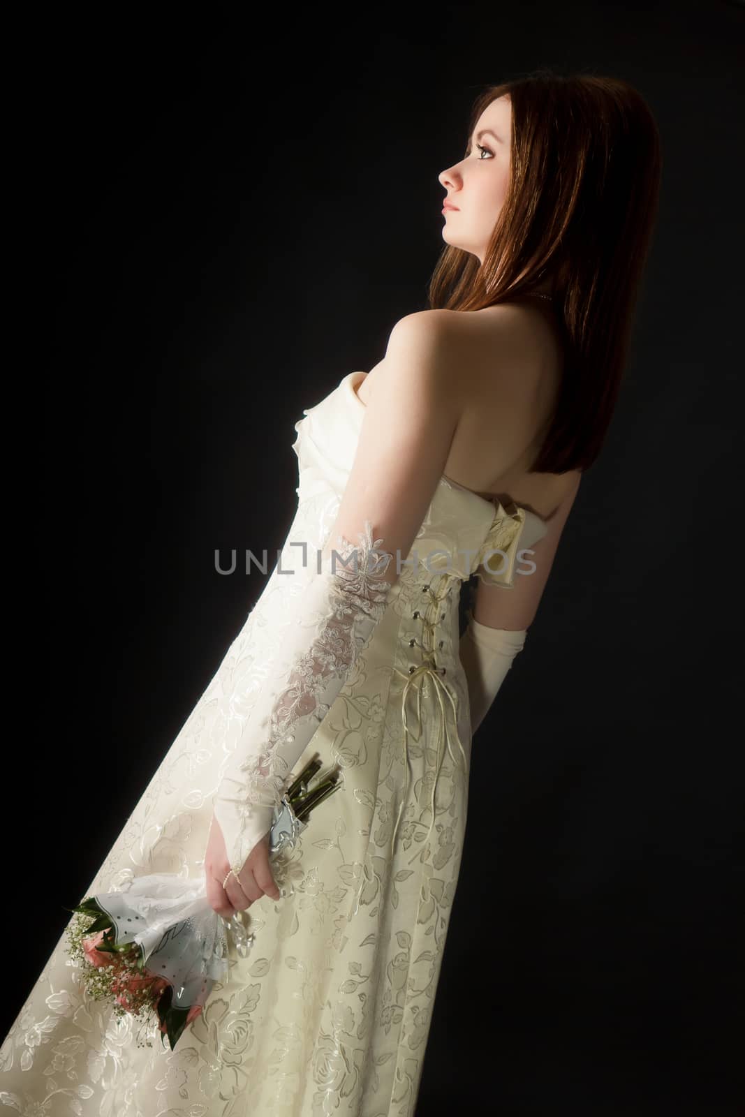 young attractive girl in a wedding dress on a black background