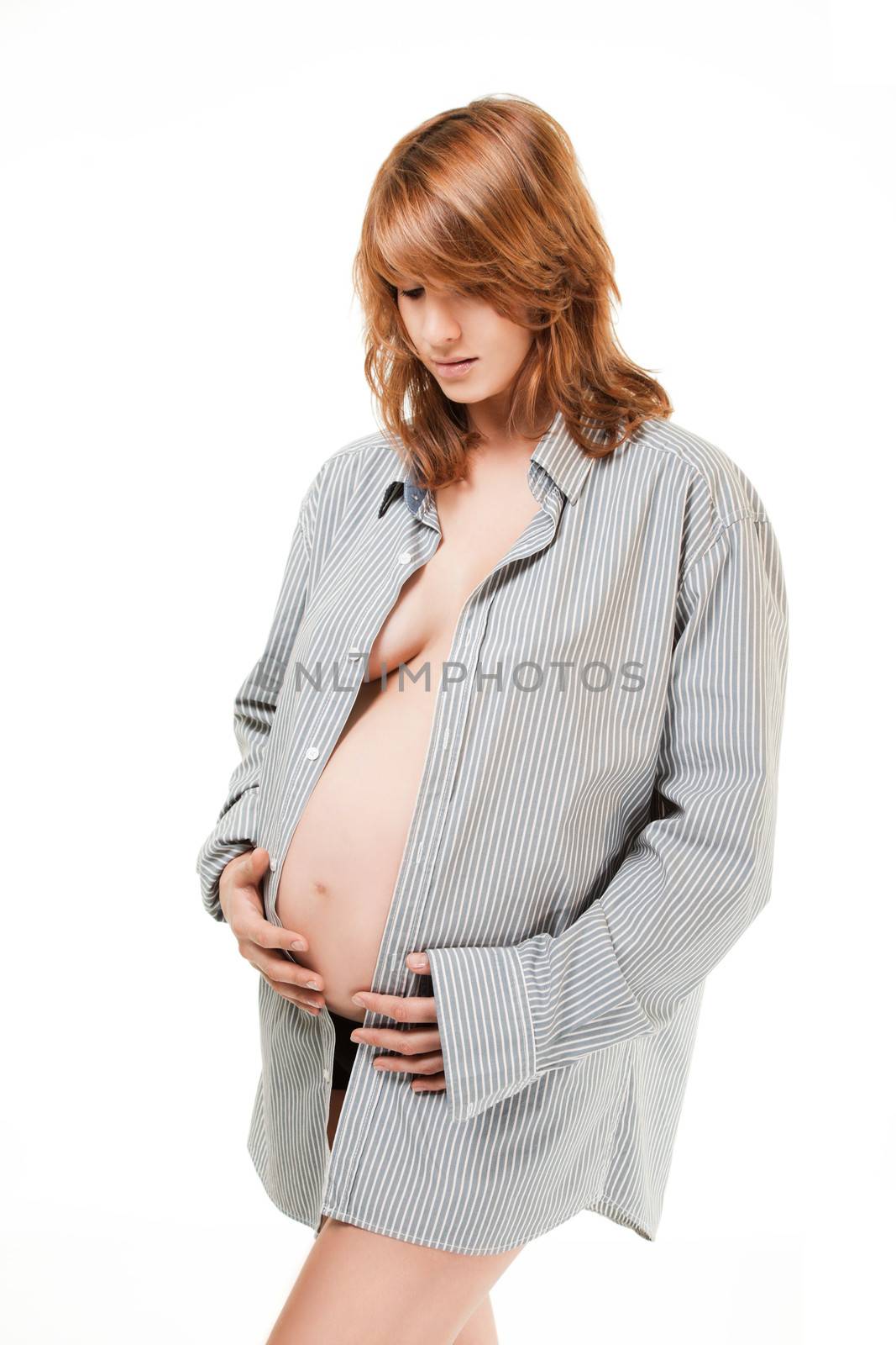 Pregnant woman looking down hands holding her tummy isolated on white