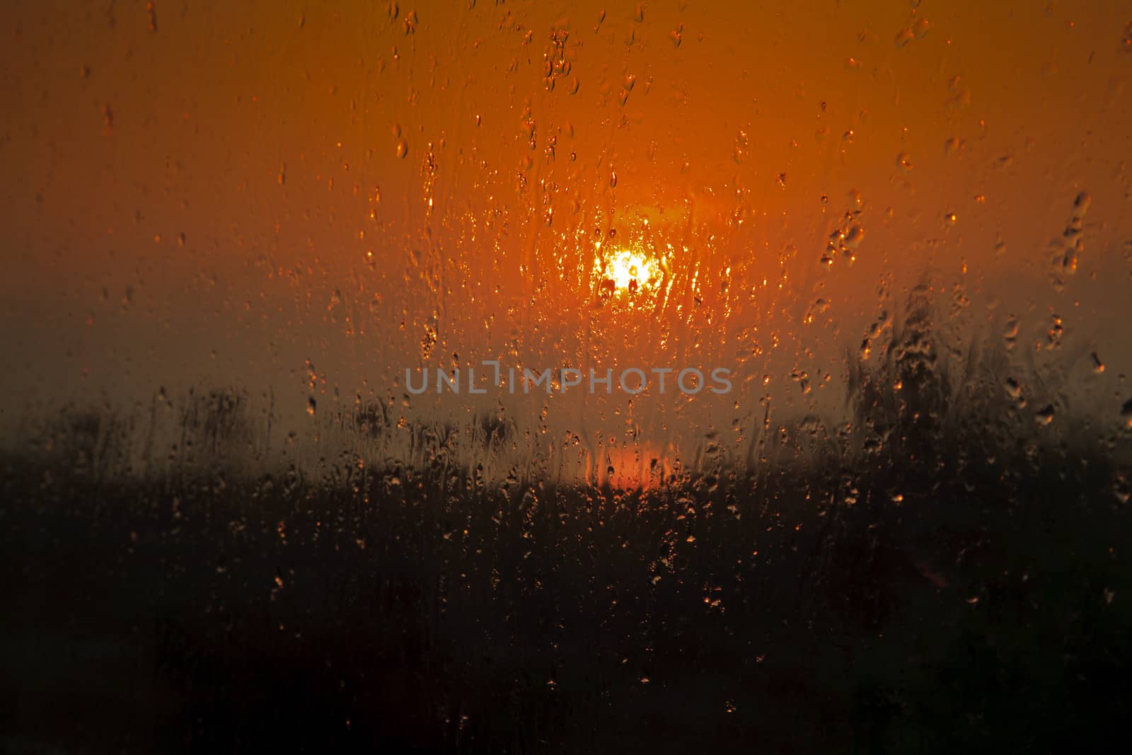 Generic Horizontal color landscape of the rising sinking sun at Manaputta Beach in Pondicherry, Tamil Nadu India. Shot taken through a steamy bathroom window.