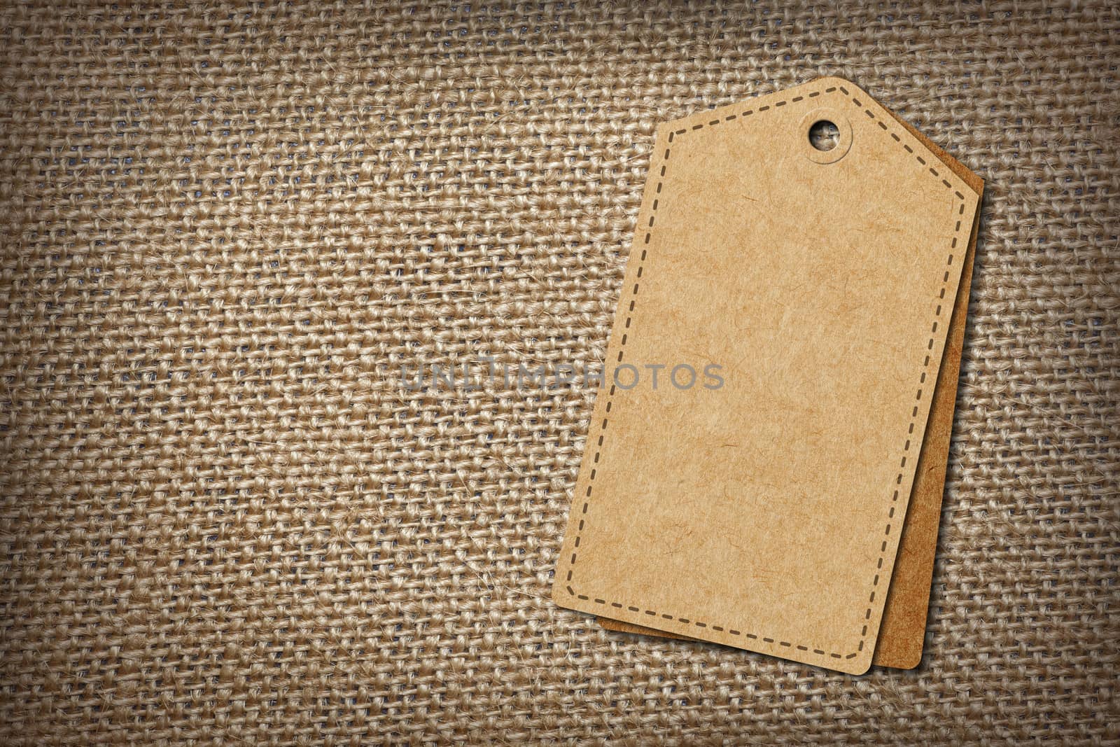 background of burlap hessian sacking with blank paper tag