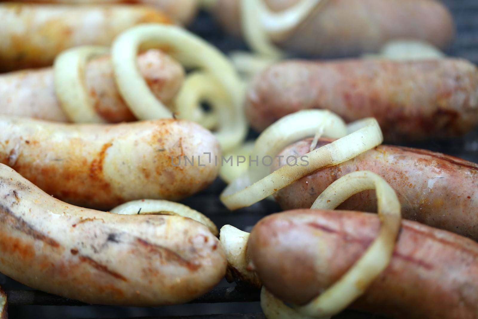 BBQ a lot of sausages with onion by indigolotos
