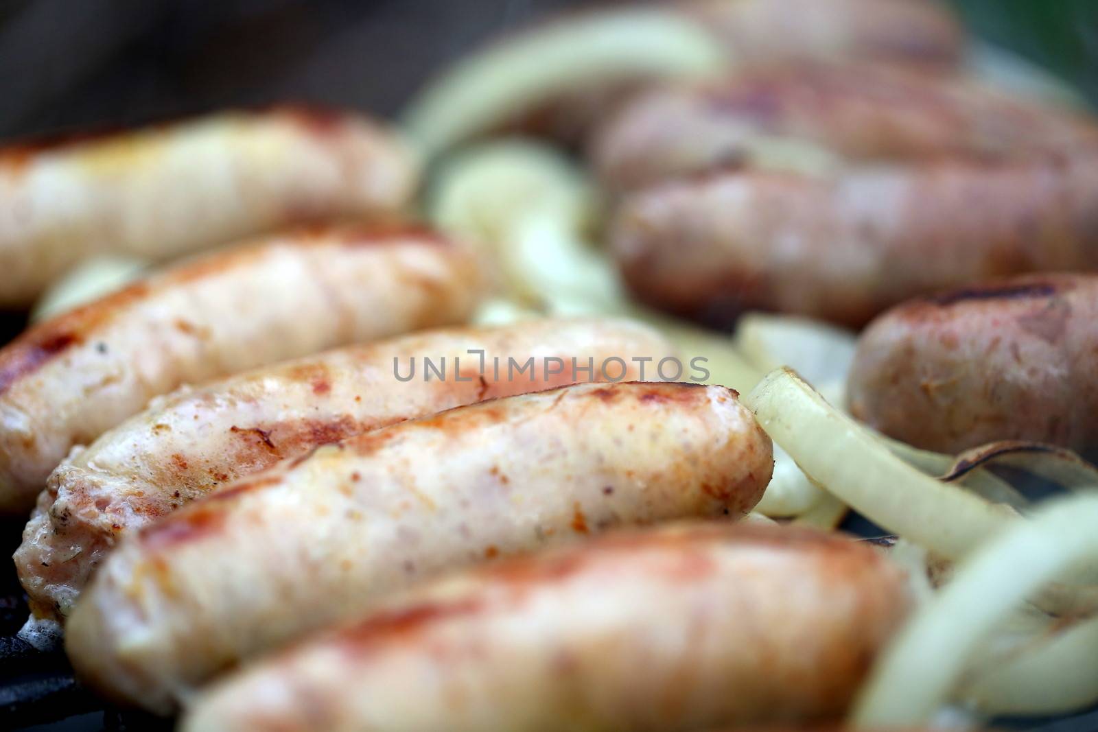 BBQ a lot of sausages with onion general background by indigolotos