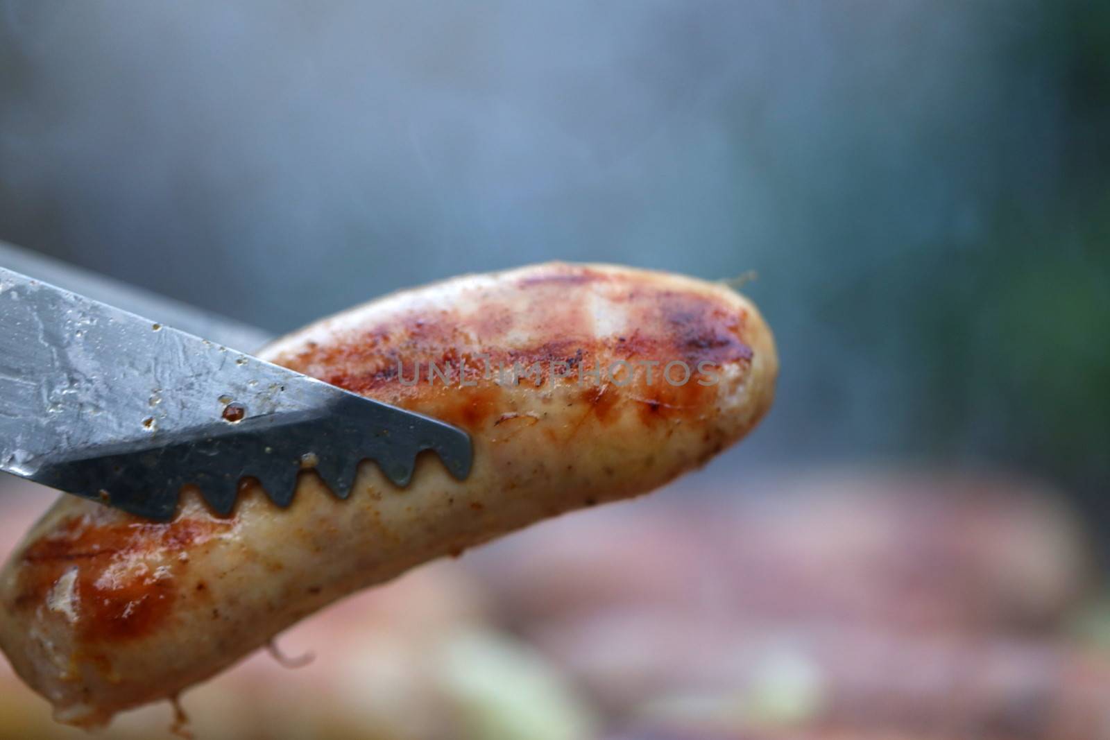 A barbecue tongs with sausege