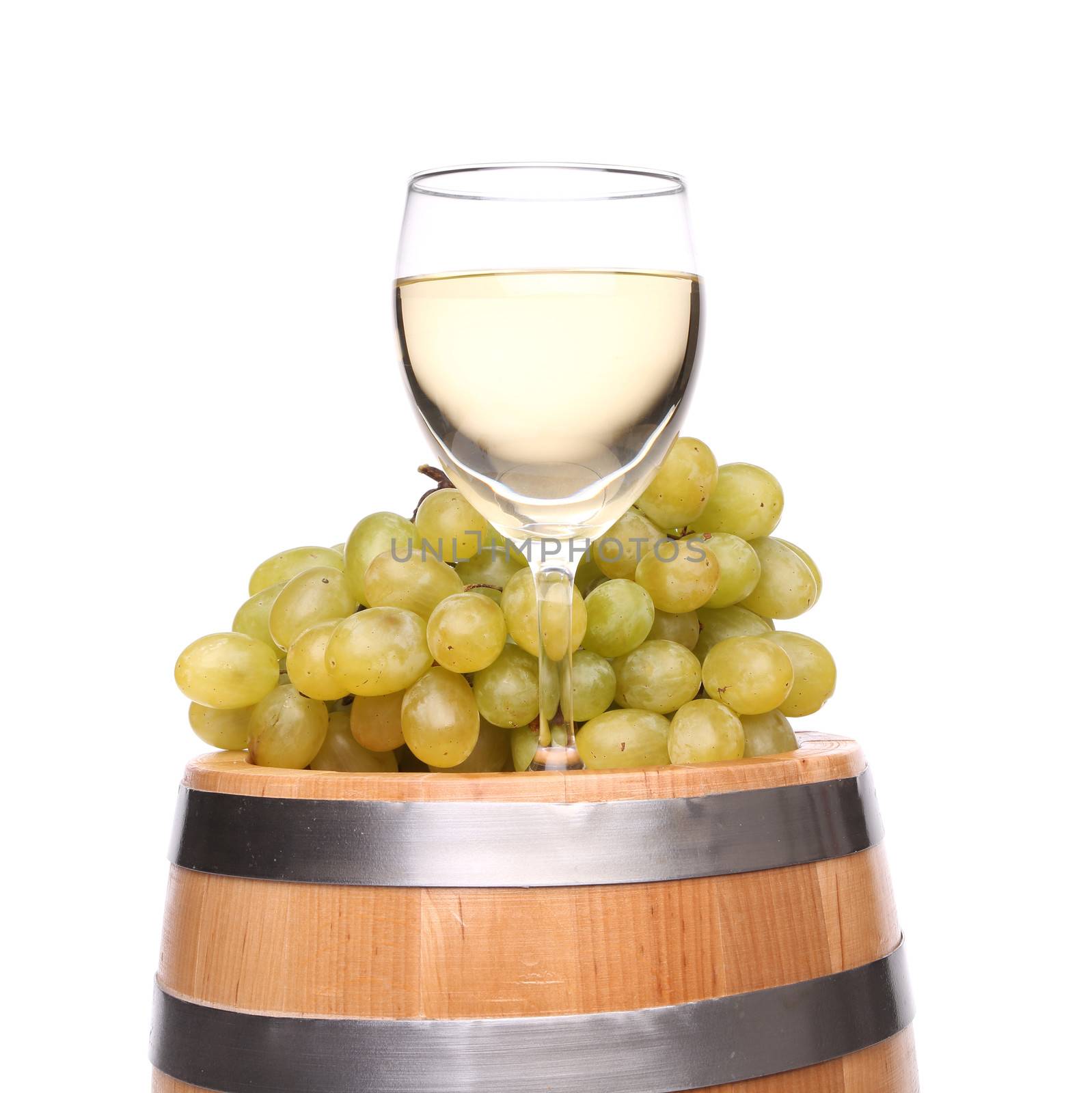 barrel, glass of wine and ripe grapes on wooden