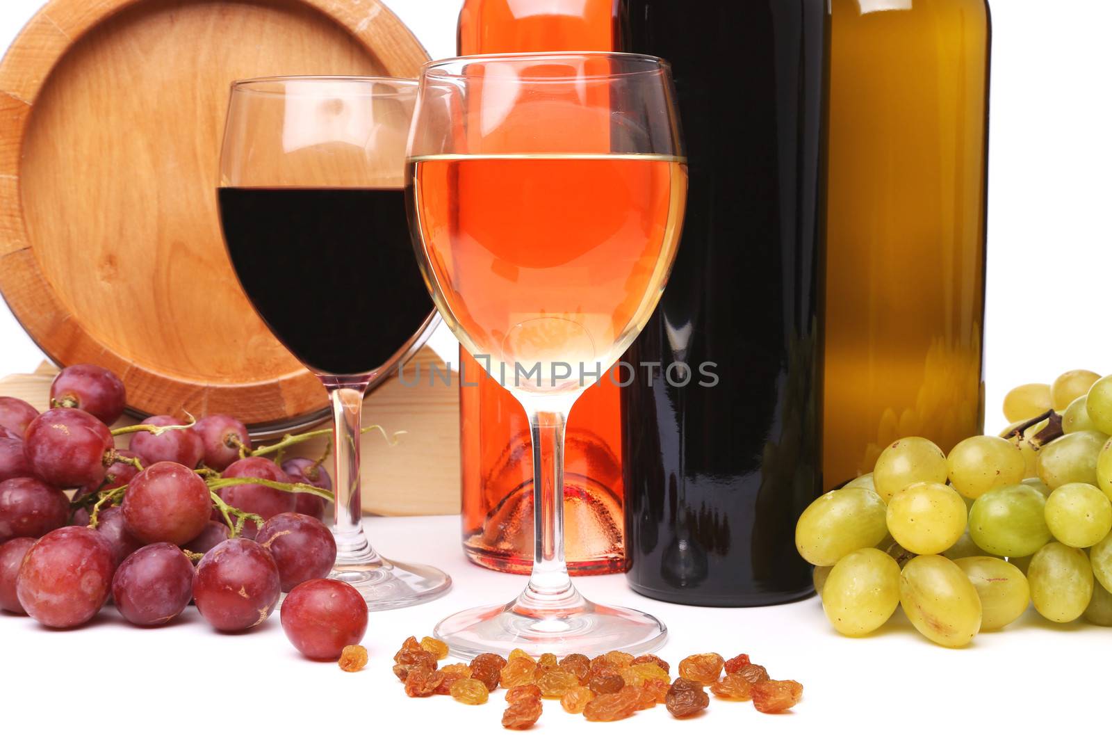 barrel, bottles and glasses of wine and ripe grapes on wooden