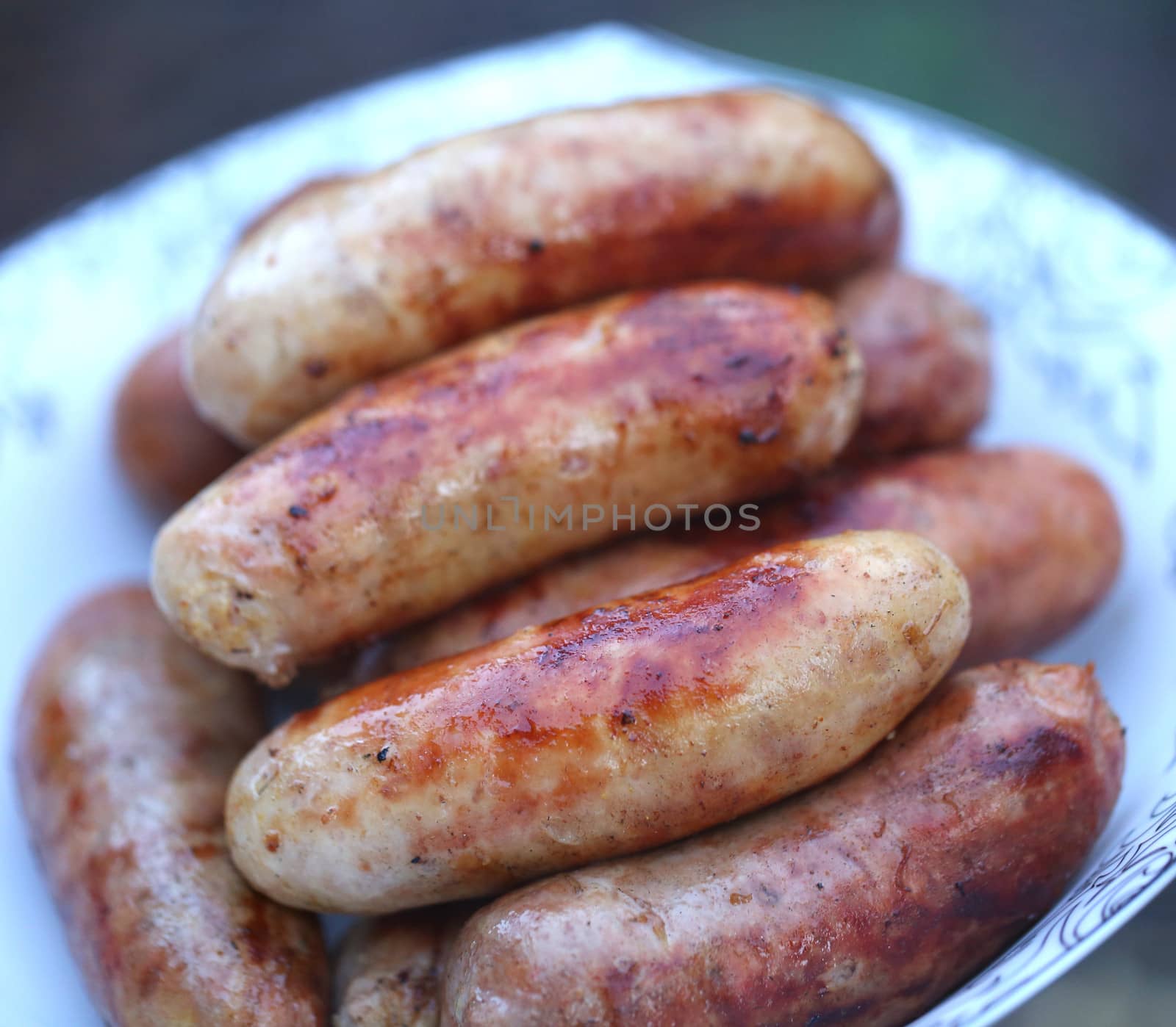 Pork sausages barbecued on the plate by indigolotos