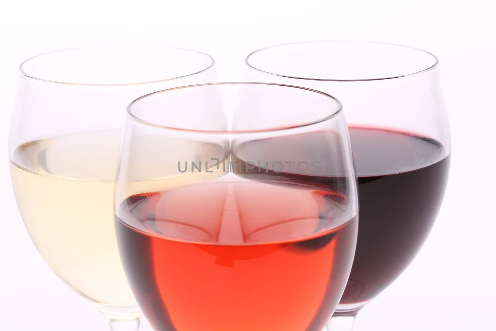 three glasses with white, rose and red wine by indigolotos