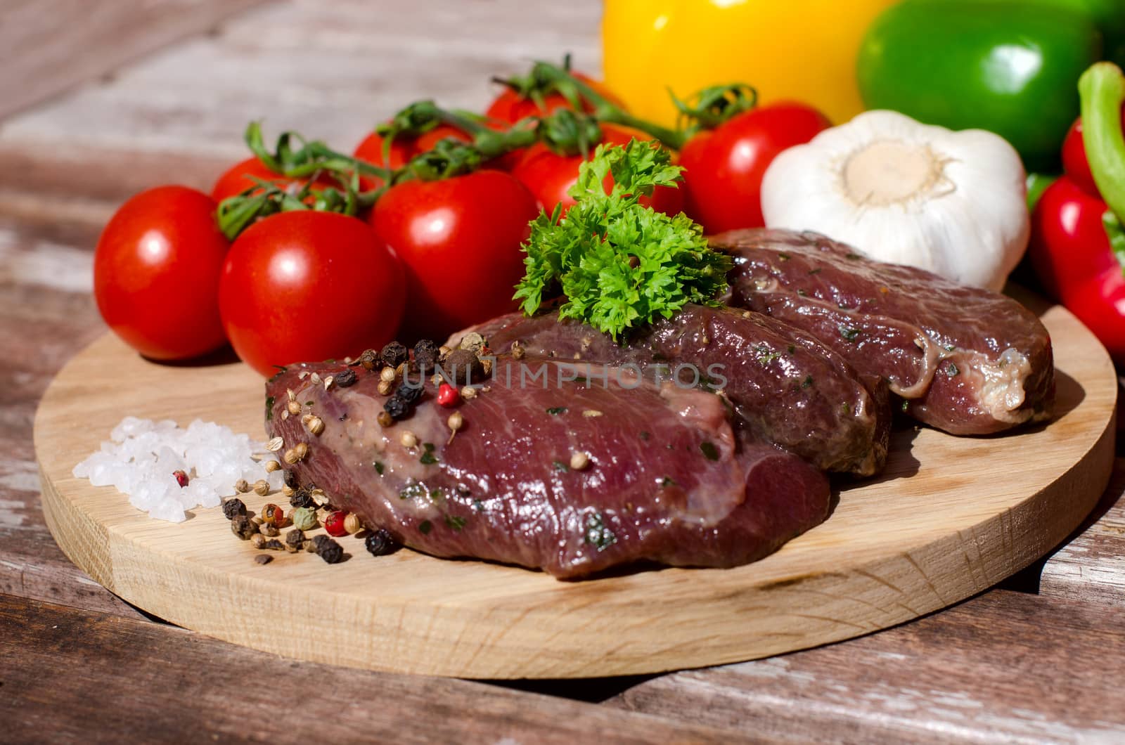 meat with fresh vegetables on wooden board