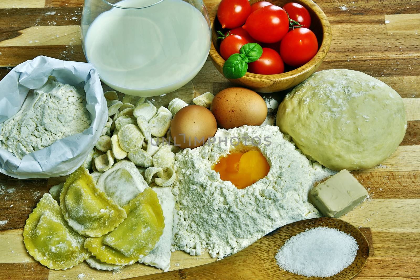 Ingredients for preparation of homemade egg pasta: flour, eggs, examples of egg pasta, tomatoes as a condiment.