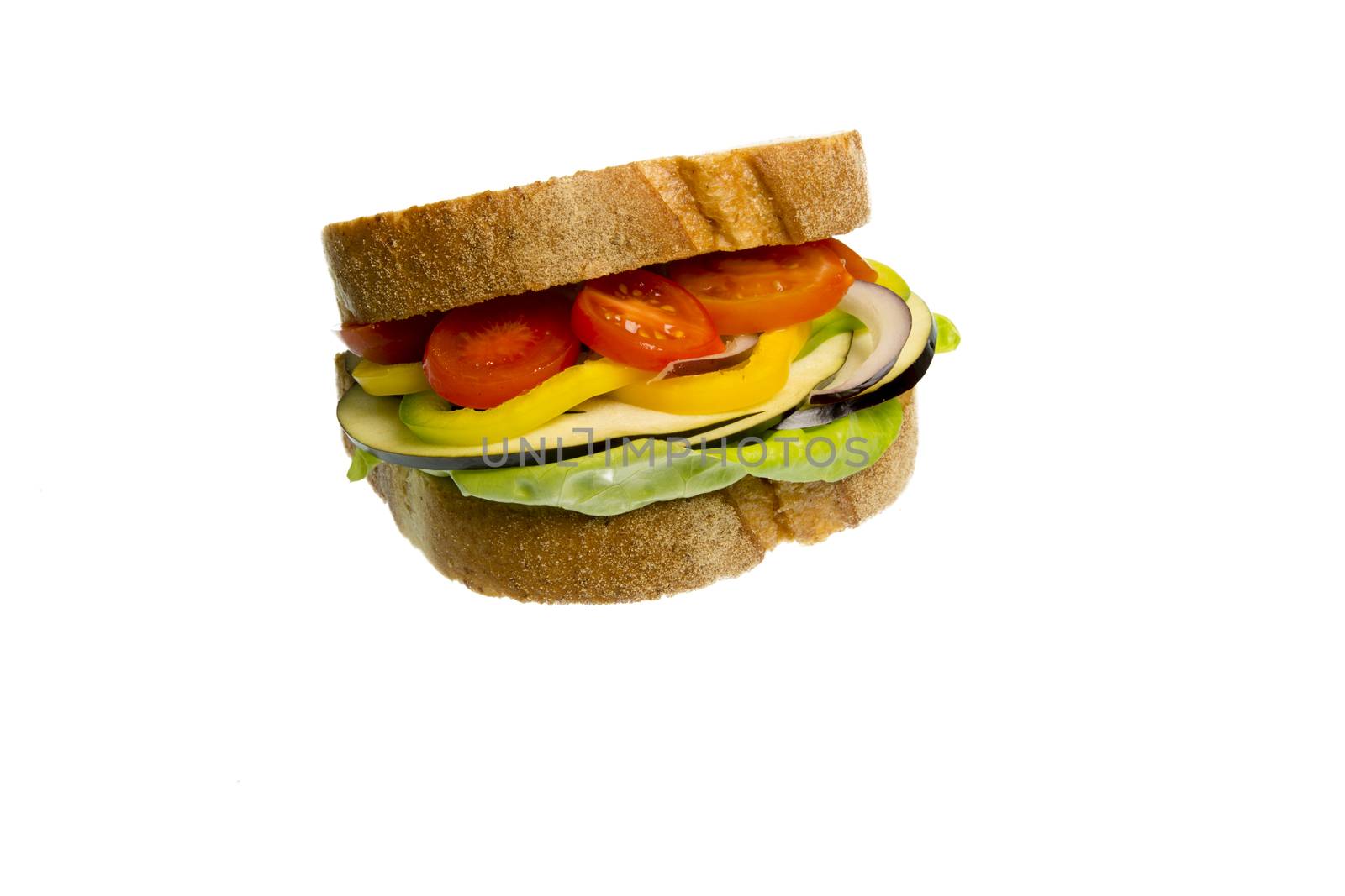 Veggie Sandwich made with lettuce, eggplant, yellow peppers, onion and tomatoes isolated on white background