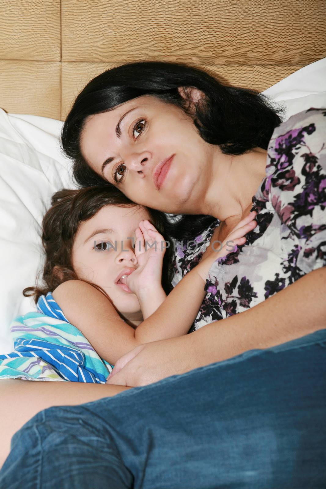 beautiful young mother and her daughter on the bed