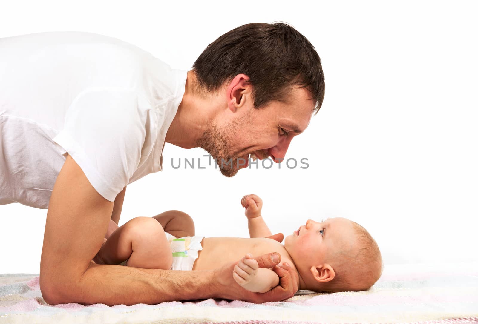 Caucasian father playing with baby son by photobac