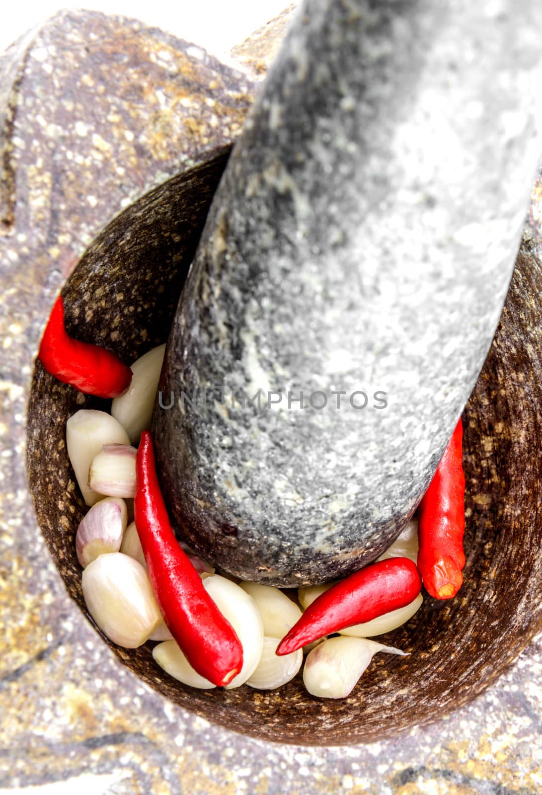 garlic and red chili pepper in stone mortar by bunwit