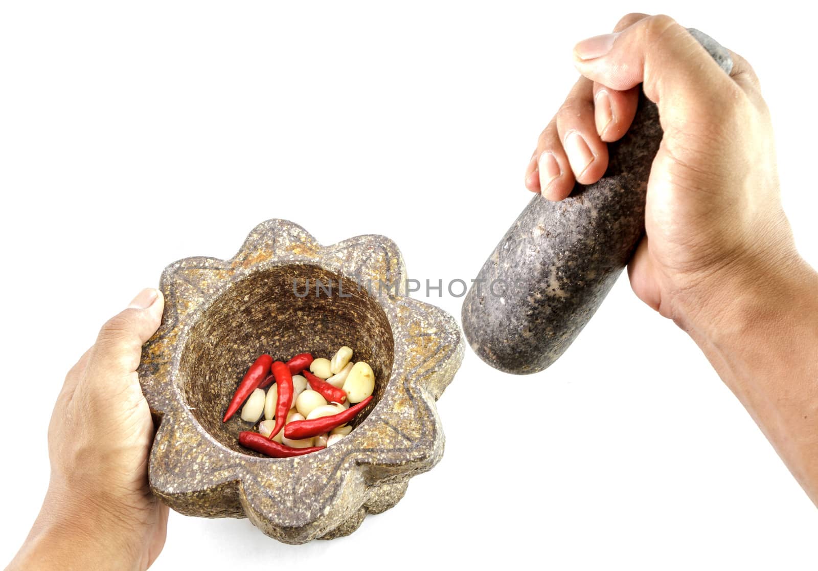 garlic and red chili pepper in stone mortar with hand holding by bunwit