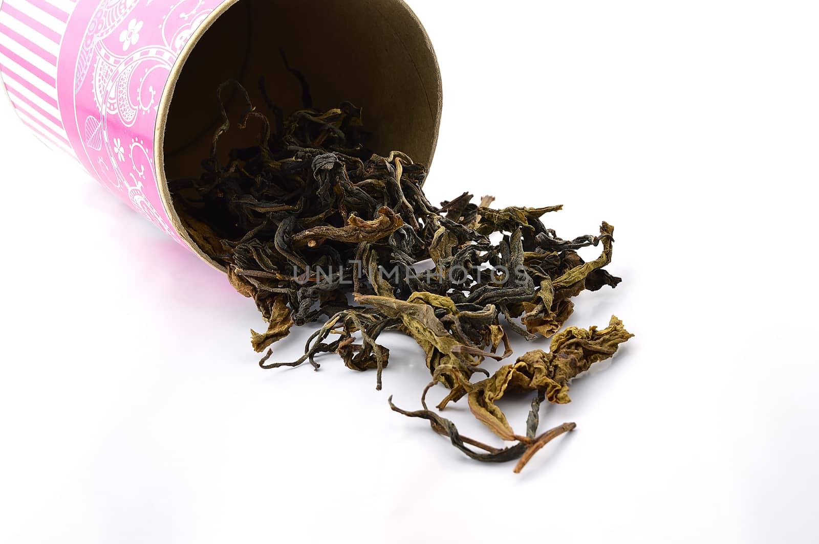dry green tea leaves spilling out from tea box isolate on white background