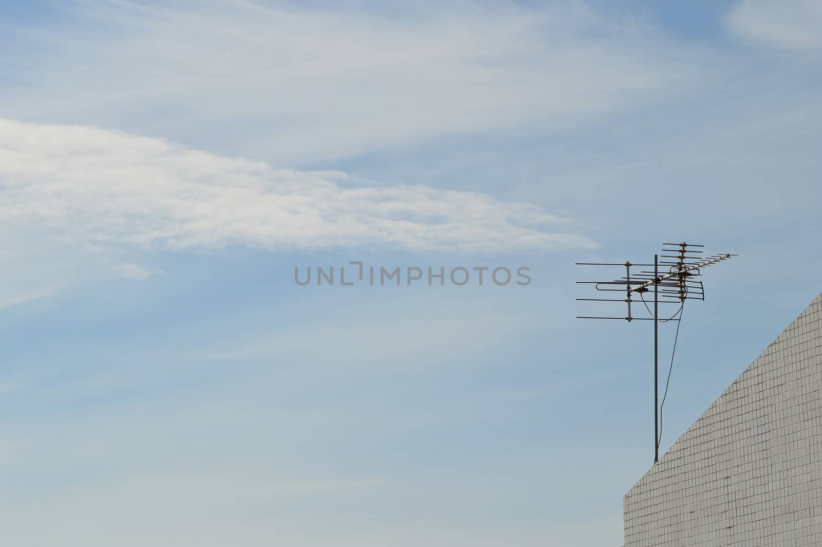 TV antenna on the roof top with blue sky
