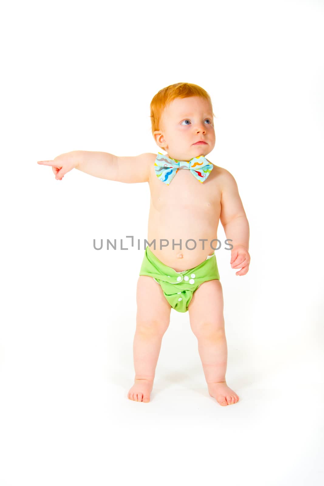 A one year old baby boy in the studio with a white background. The kid is wearing a bowtie and a diaper.
