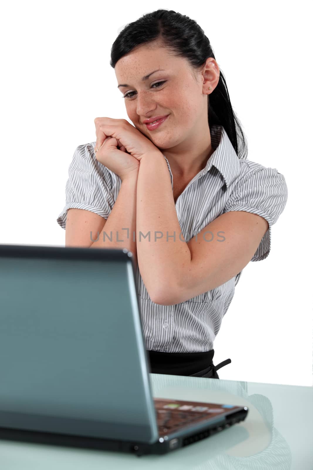 Excited brunette sat at desk by phovoir