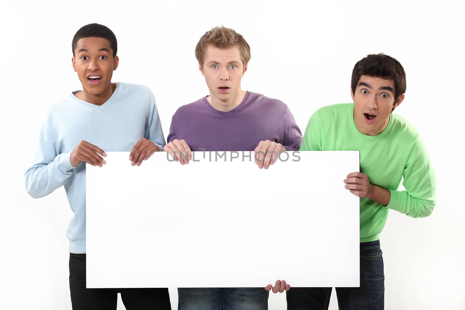 Three surprised men holding poster by phovoir
