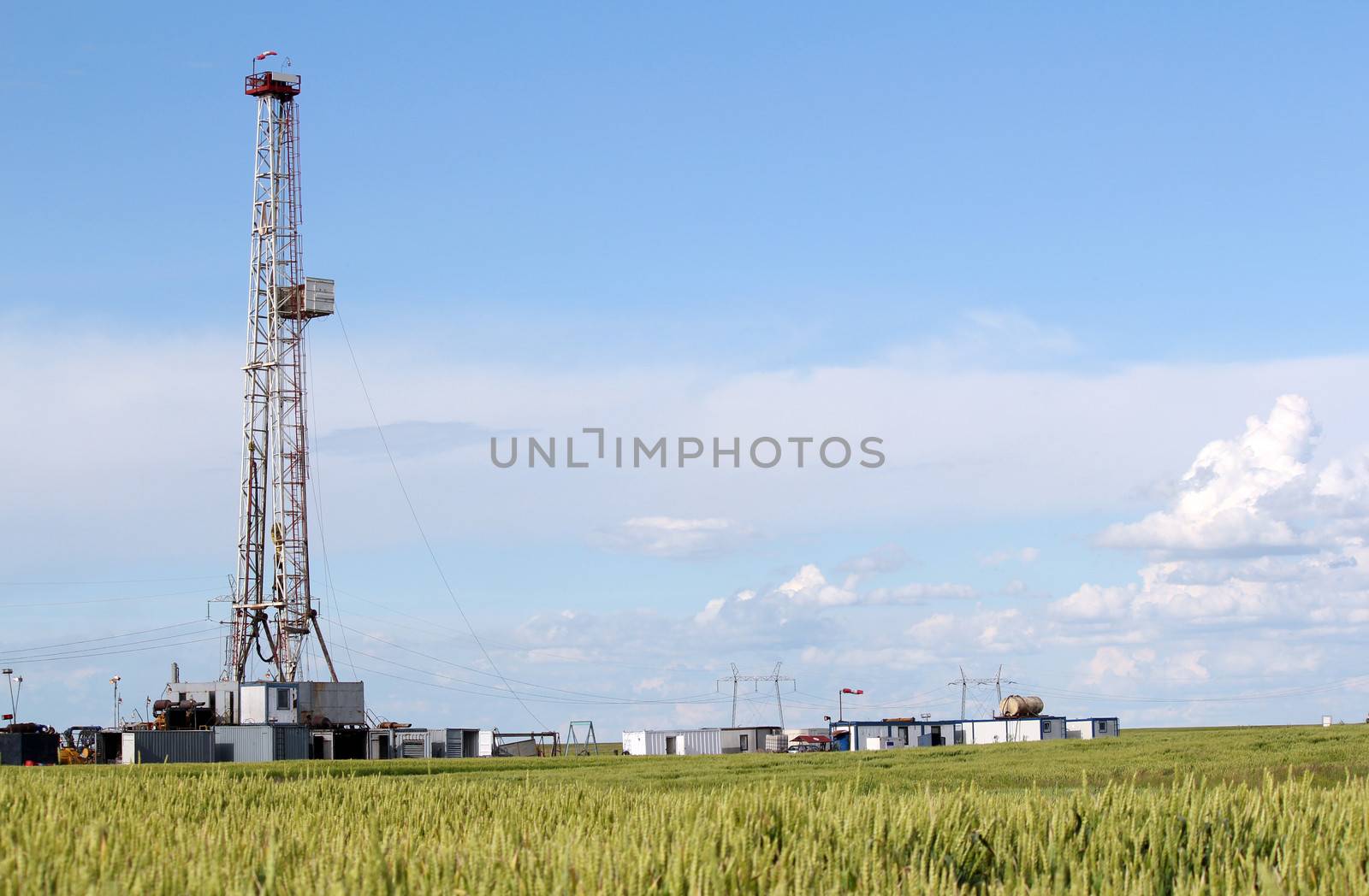 field with oil drilling rig by goce