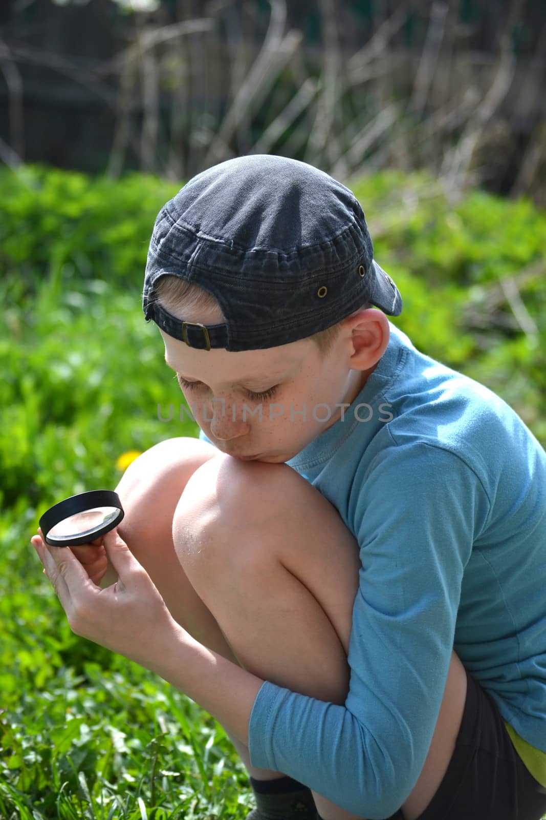 the teenager observes through magnifying glass