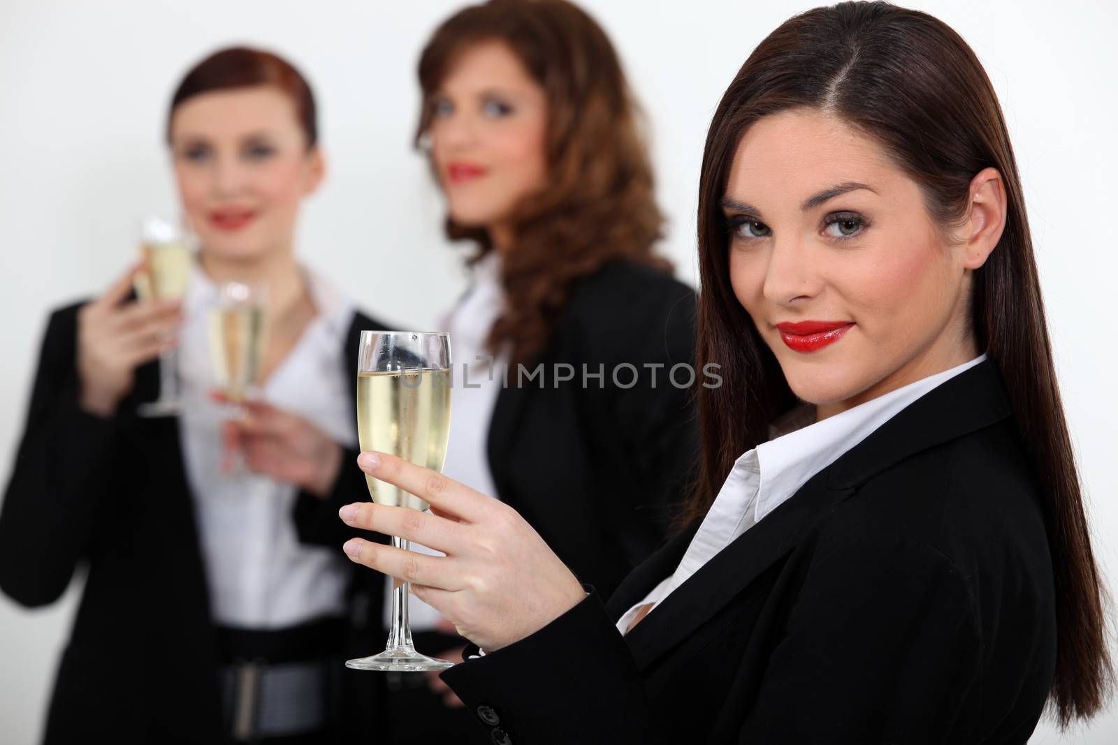 Women toasting with champagne by phovoir