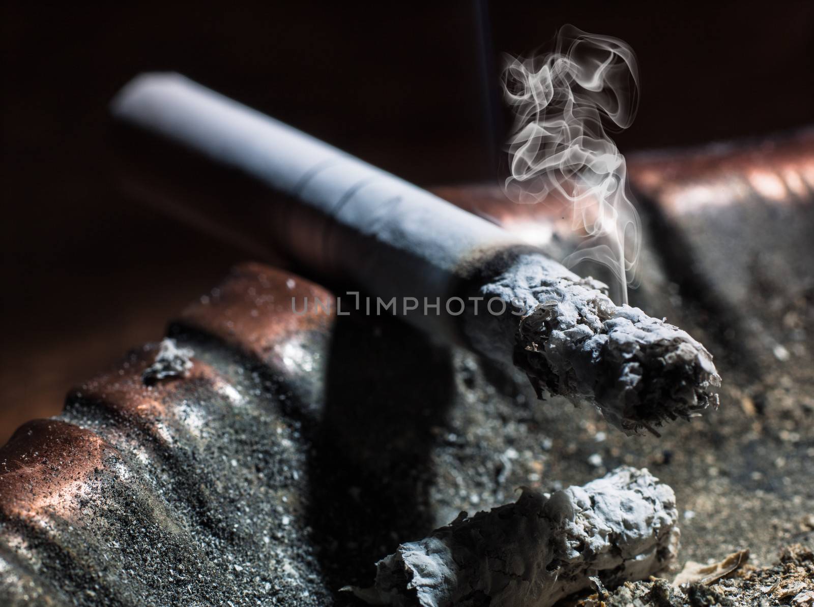 the cigarette emitting smoke burning in an ashtray by oleg_zhukov