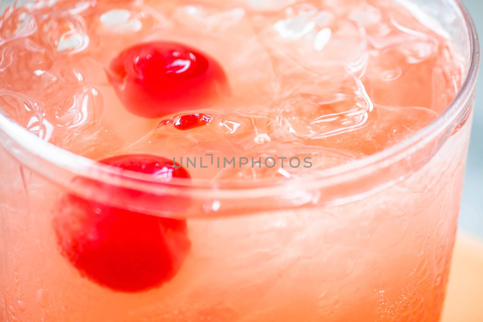 Glass of mix fruits juice soda with cherry up close
