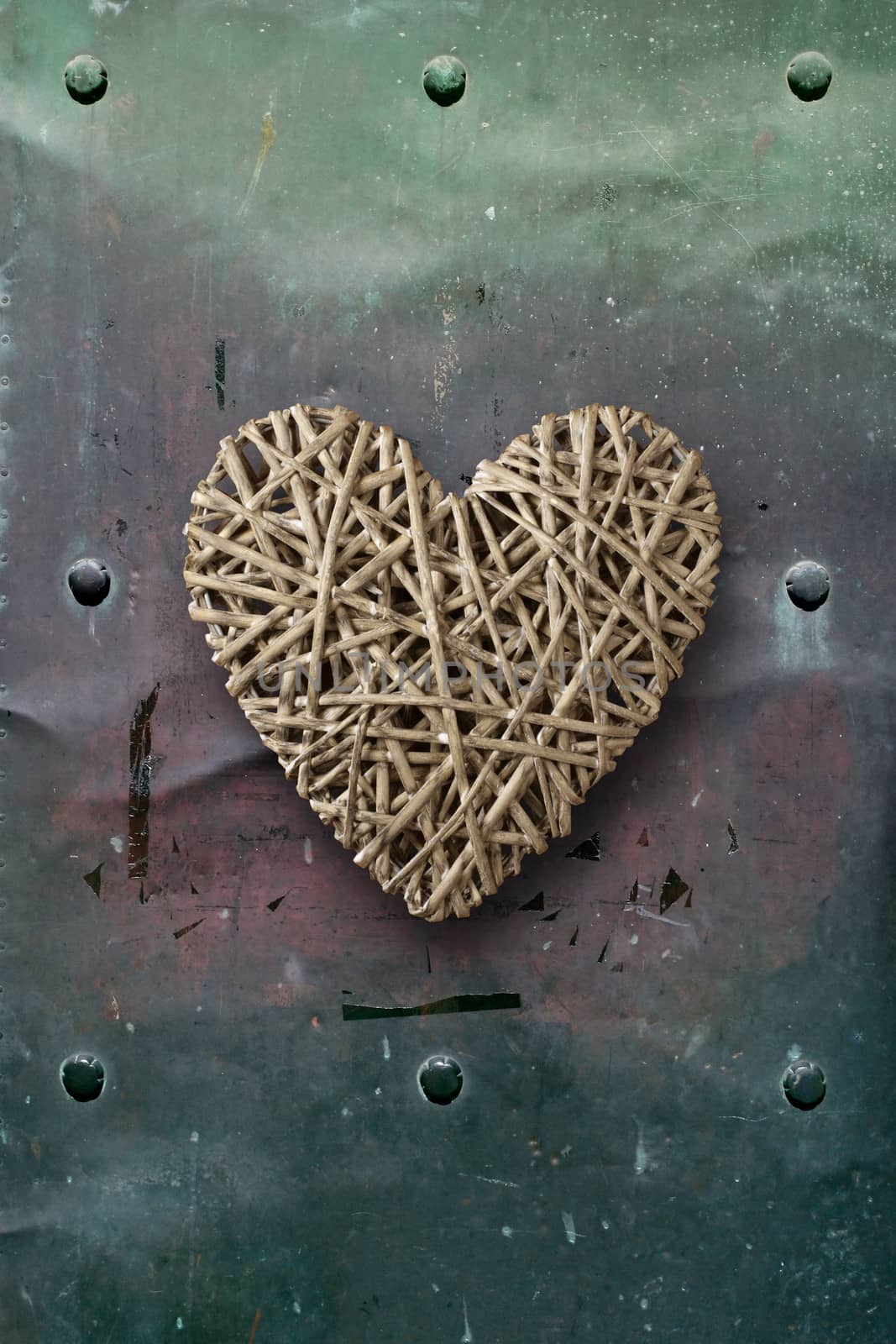 Photo of a wooden heart on top of old metal background.
