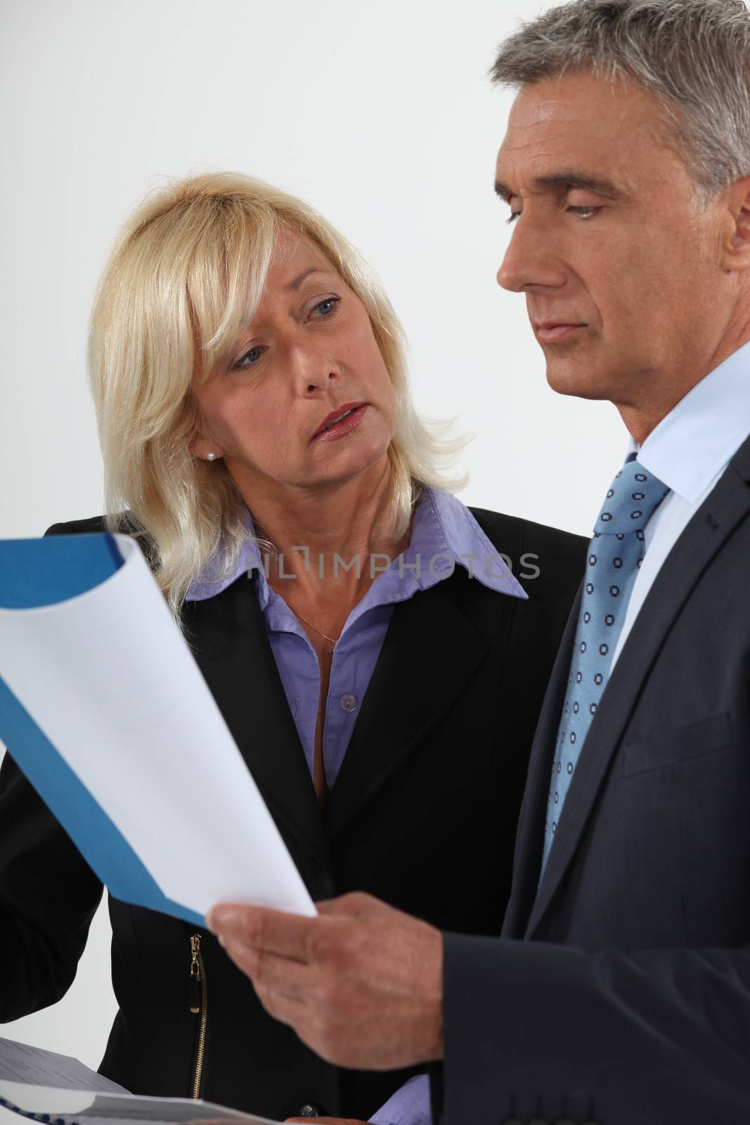 Senior business couple going over important document