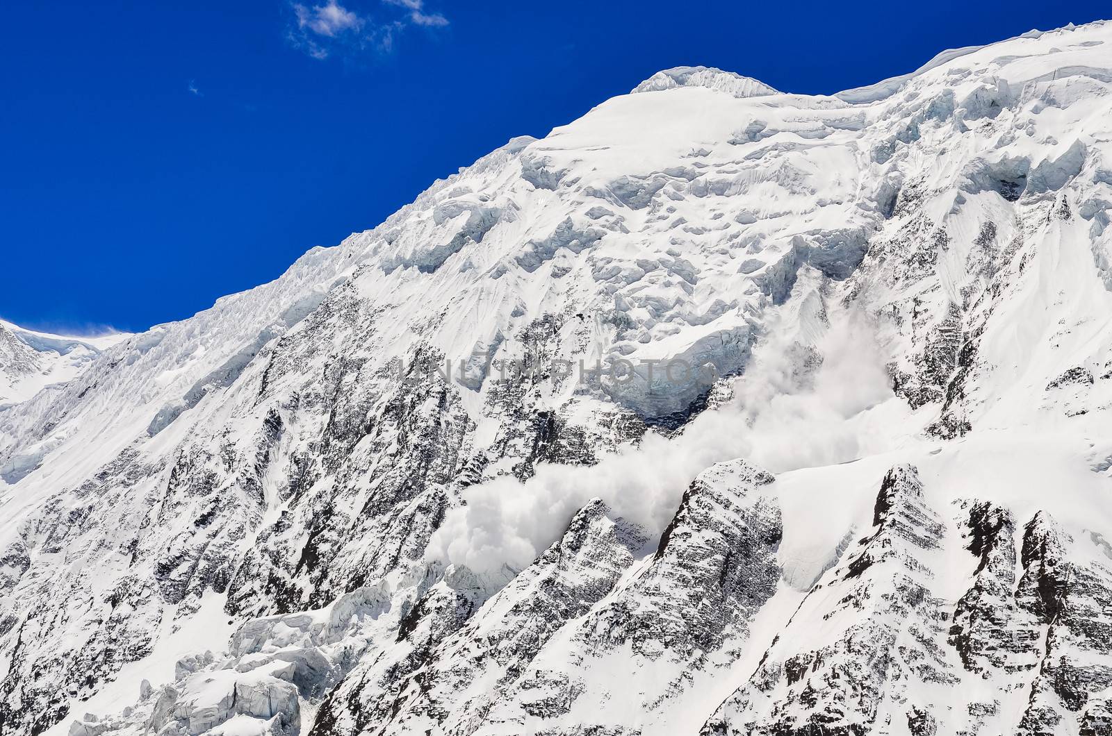 Avalanche falling from snowy frozen mountain peak by martinm303