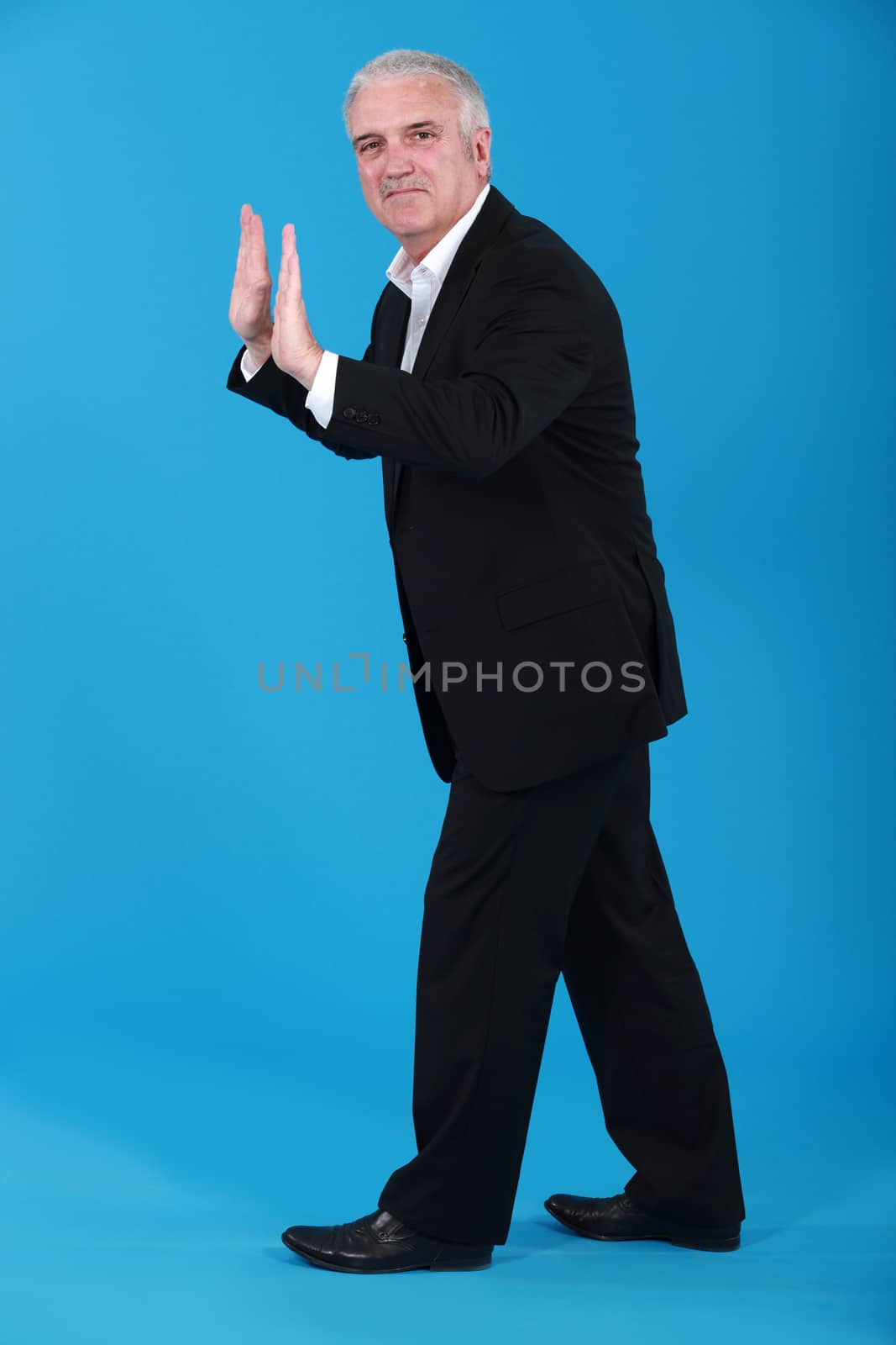 A businessman making a push gesture.