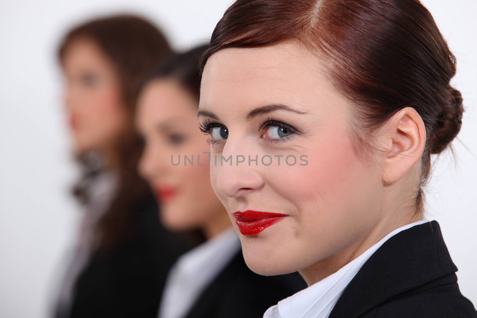 Businesswomen stood in a row by phovoir