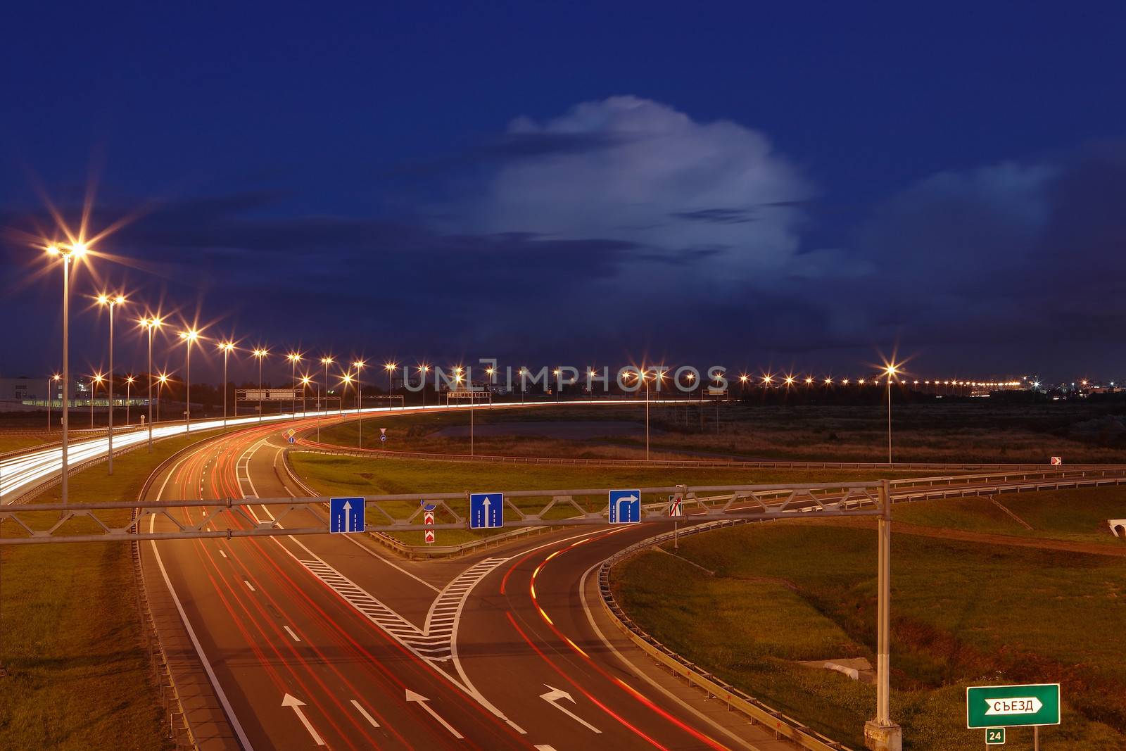 Ringway St Petersburg. Russian road at night, with markings, road signs and lighting masts. by grigvovan