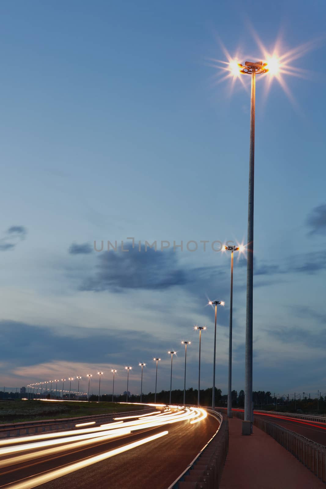 Road lighting, lighting columns, night highway. by grigvovan